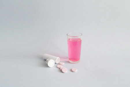 A glass of hot water and an antipyretic dissolving tablet in a glass.の写真素材