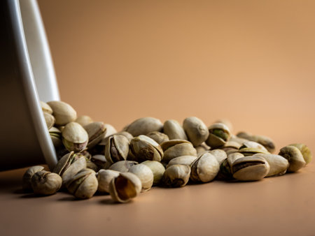 Pistachios in a white cup on a brown background.の写真素材