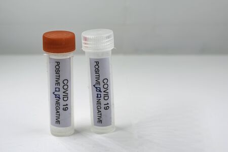 Testing for presence of coronavirus. Tube containing a swab sample that has tested positive for...