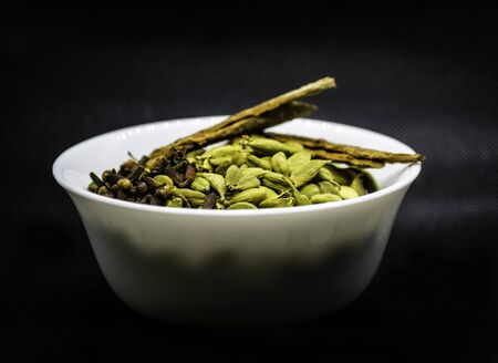 isolated view of spices in a white bowl with black backgroundの写真素材