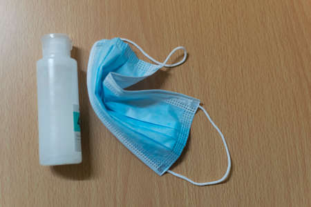 a mask and hand clean liquid on the tableの写真素材