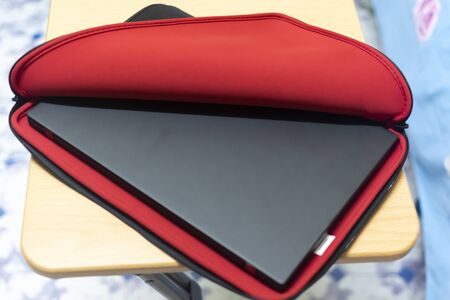 A laptop in an opened black and red sleeveの写真素材