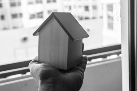 a wooden toy home in hand suitable for construction addsの写真素材