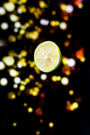 levitating lemon in to the water with light bokeh background