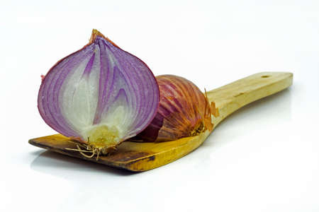 Red sliced onion on wooden cooking spatula isolated on white backgroundの写真素材