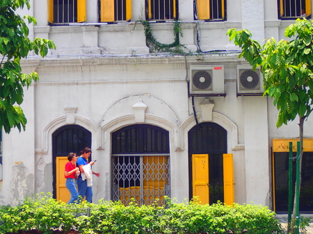 Kuala Lumpur, Malaysia. April 5 2018. Two women walks pass the facade of old building in Kuala Lumpur, Malaysia.のeditorial素材