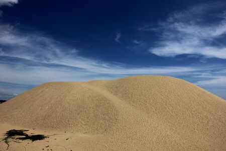 Sand dune under blue, thin clouded sky at Pantai Mek Mas, Kelantan.の写真素材