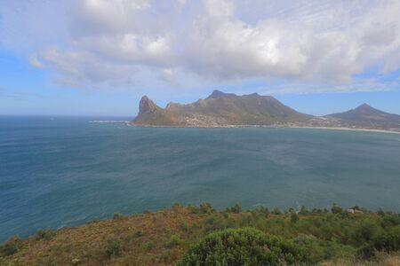 The view of Hout Bay and Atlantic Ocean as seen from fynbos clad sea side at road side viewing point of Chapman's Peak Drive in Cape Peninsula, South Africa.の写真素材