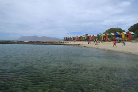 St James, Cape Town, South Africa - March 11 2020 : A view of tidal pool and beach with people and colorful Victorian-style beach huts at Saint James Beach, near Kalk Bay in South Africa.のeditorial素材