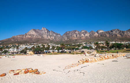 Camps Bay Beach in Camps Bay with town and Twelve Apostles Mountain range in the background at the outskirt of Cape Town, South Africa.の写真素材
