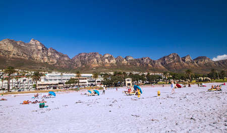 Camps Bay Beach in Camps Bay with town and Twelve Apostles Mountain range in the background at the outskirt of Cape Town, South Africa.のeditorial素材