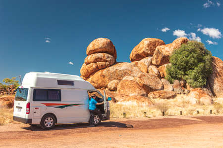 A camper van at rock formations of Devil`s Marbles or Karlu Karlu, in Northern Territory, Australia.の写真素材