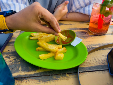 French fries served on a wooden table, ready to be enjoyed.の写真素材