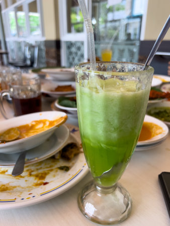 Cold cucumber juice, a refreshing glass of cucumber juice on the dining table.の写真素材
