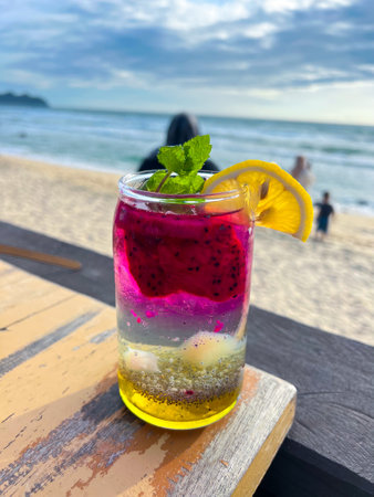 A cold and refreshing dragon fruit cocktail is placed on the table of a restaurant located by the beach, perfect to enjoy and very refreshing.の写真素材