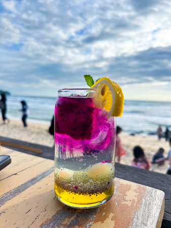 A cold and refreshing dragon fruit cocktail is placed on the table of a restaurant located by the beach, perfect to enjoy and very refreshing.の写真素材