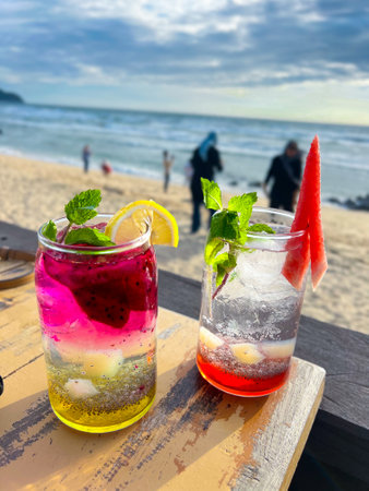 A cold and refreshing watermelon cocktail and dragon fruit cocktail are placed on the table at a restaurant located by the beach, perfect for enjoying and very refreshing.の写真素材
