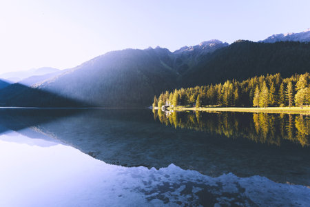 Mountain lake at sunrise with reflection of mountains in the water.の写真素材