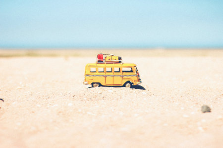 Yellow toy school bus on the sand of the beach. Retro styleの写真素材
