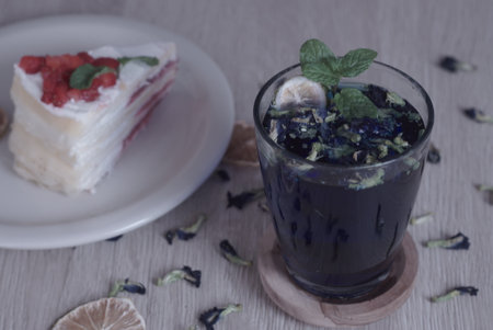 Teh Bunga Telang, Butterfly pea tea with dry lemon with a slice of cake, Selective Focus