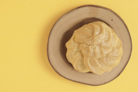 Kue Soes or choux Ã  la crÃ¨me isolated on a yellow background. Perfectly puffed and filled with a creamy filling, this classic French dessert is sure to delight. Selective Focus , Closeupの写真素材