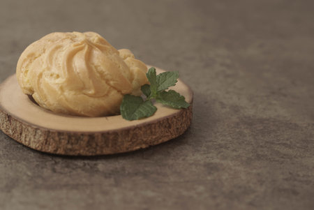 ue Soes or choux Ã  la crÃ¨me on wooden plate. Perfectly puffed and filled with a creamy filling, this classic French dessert is sure to delight. Selective Focus , Closeupの写真素材