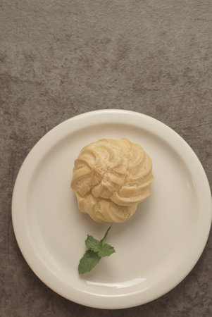 Kue Soes or choux Ã  la crÃ¨me on white plate. Perfectly puffed and filled with a creamy filling, this classic French dessert is sure to delight. Selective Focus , Closeupの写真素材
