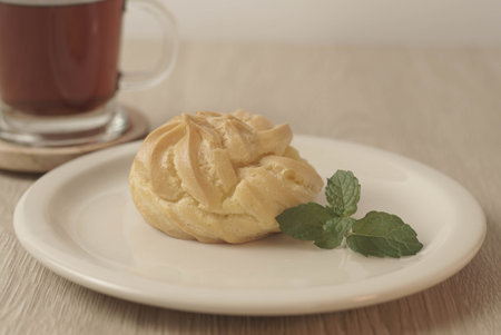 Kue Soes or choux Ã  la crÃ¨me on white plate. Perfectly puffed and filled with a creamy filling, this classic French dessert is sure to delight. Selective Focus , Closeupの写真素材