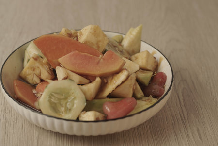 Rujak Buah is an Indonesian dessert consisting of fresh tropical fruit. That is mixed with a sweet and spicy sauce made from palm sugar, tamarind, chili, garlic and salt. Selective focus , Closeupの写真素材
