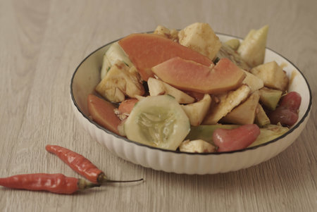 Rujak Buah is an Indonesian dessert consisting of fresh tropical fruit. That is mixed with a sweet and spicy sauce made from palm sugar, tamarind, chili, garlic and salt. Selective focus , Closeupの写真素材