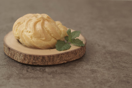 ue Soes or choux Ã  la crÃ¨me on wooden plate. Perfectly puffed and filled with a creamy filling, this classic French dessert is sure to delight. Selective Focus , Closeupの写真素材
