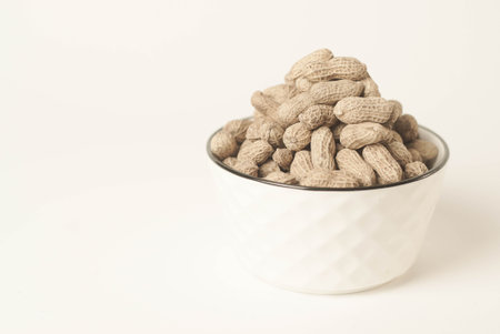 This high-quality image showcases perfectly roasted peanuts isolated on a clean white background, perfect for your food-related projects or blogsの写真素材