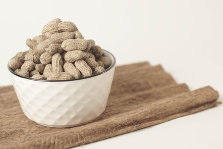 This high-quality image showcases perfectly roasted peanuts isolated on a clean white background, perfect for your food-related projects or blogsの写真素材
