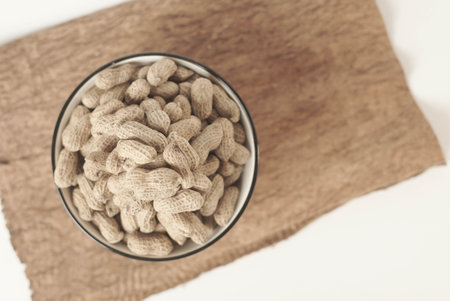 This high-quality image showcases perfectly roasted peanuts isolated on a clean white background, perfect for your food-related projects or blogsの写真素材