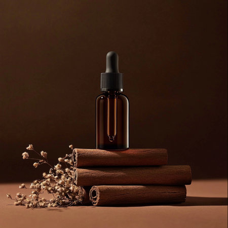 Cinnamon essential oil in a glass bottle on a brown background.の素材