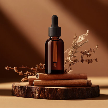 Aromatherapy essential oil in brown glass bottle with cinnamon stick on brown backgroundの素材