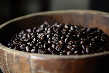 Coffee beans in a wooden bowl on a dark background.の素材