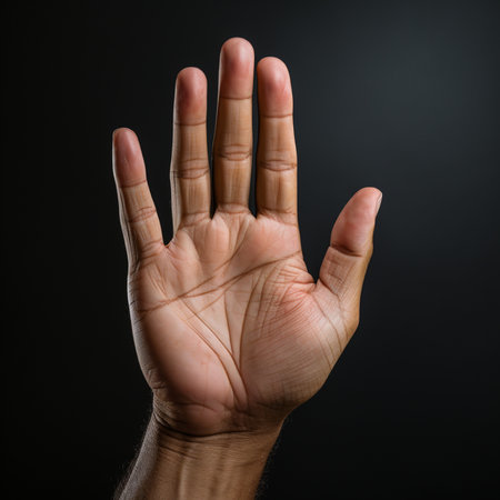 Man's hand showing three fingers on a dark background, close upの素材