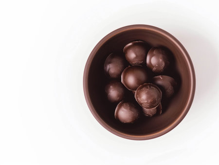Chocolate candies in bowl on white background. Top view.の素材