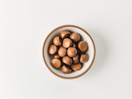 Chocolate candies in bowl on white background. Top view.の素材