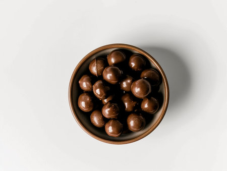 Chocolate candies in bowl on white background. Top view.の素材