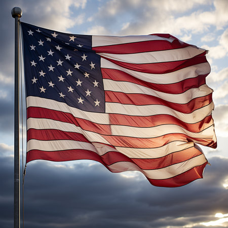 A vibrant American flag waves against a dramatic sky at sunset, symbolizing patriotism and freedom. The flags colors are vivid, and the sky adds depth.の素材