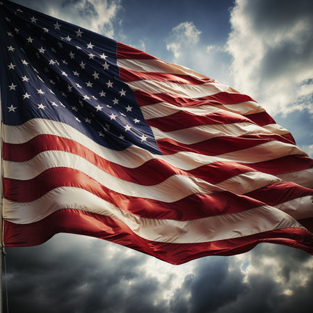 A vibrant American flag waves against a backdrop of dramatic clouds, symbolizing patriotism and freedom.の素材