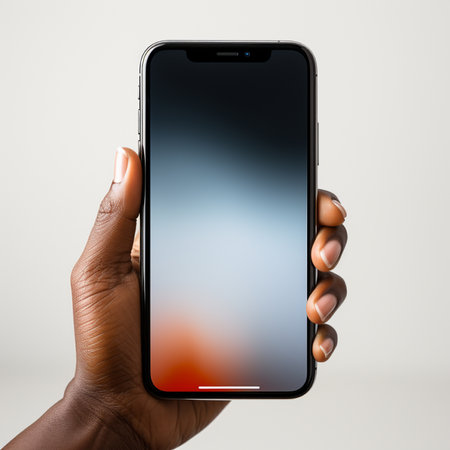 A detailed view of a person's hand, showcasing skin texture, gently gripping a sleek smartphone displaying a vibrant, out-of-focus background.の素材