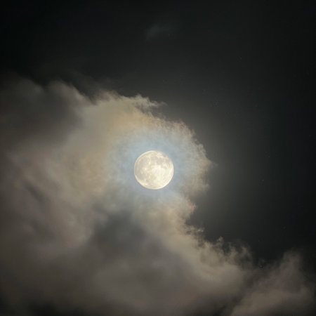 Full moon in the dark night sky with clouds, closeup of photoの素材