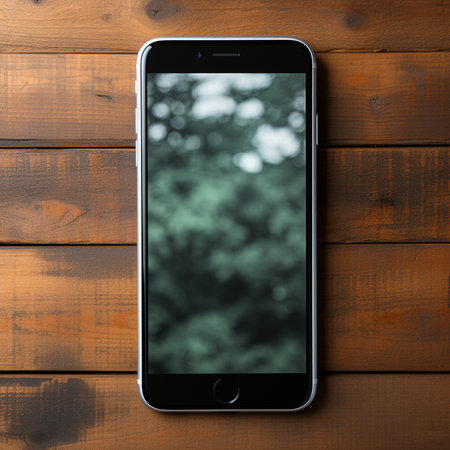 Smartphone on wooden background. Mobile phone on wooden table. View from above.の素材