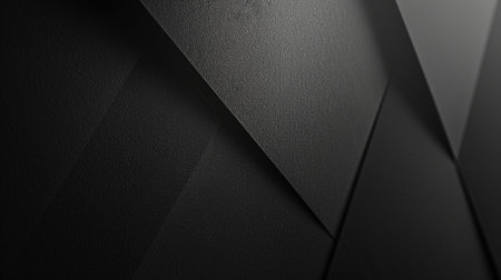 A dark, textured geometric surface with sharp, angular planes and soft shadows, creating a modern abstract backdrop.の素材