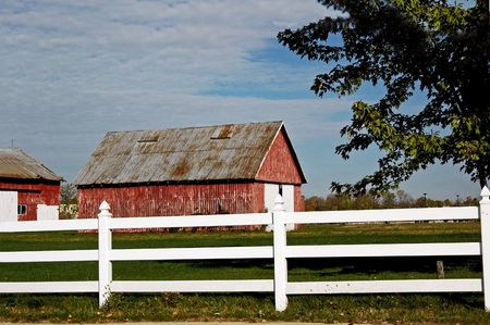 Farm with white fence in front.の写真素材