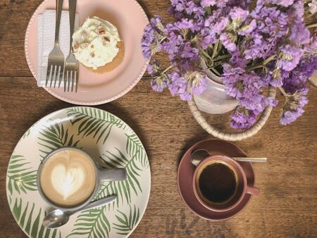 Cup of cappuccino with latte art and xpresso on a wooden plate and wooded table decorated with dried flower, Selective focus, Soft focusの写真素材