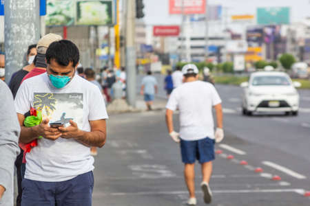 Lima, Peru - April 8, 2020: Men in line doing social distancing practices in the middle of a coronavirus outbreak in South America. Men's day only, gender-based quarantine, men lined up to buy groceries.のeditorial素材